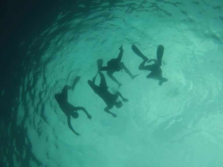 Snorkeling en Méditerranée — quatre nageurs vus sous l'eau, eaux turquoise et lumière diffuse
