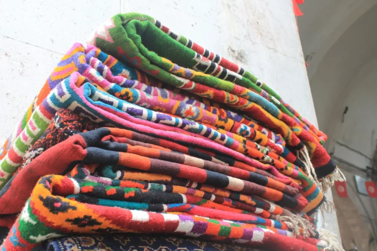 Tapis traditionnels tunisiens tissés à la main — étal d'artisanat dans un souk de Tunisie