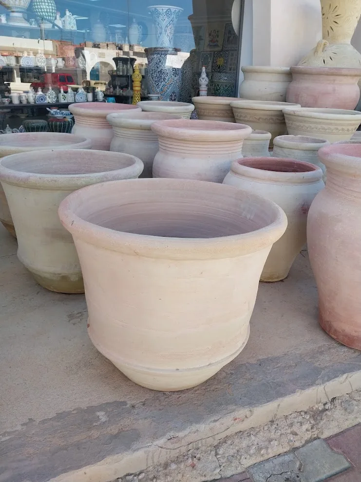 Poteries en terre cuite empilées devant une boutique d'artisanat à Guellala