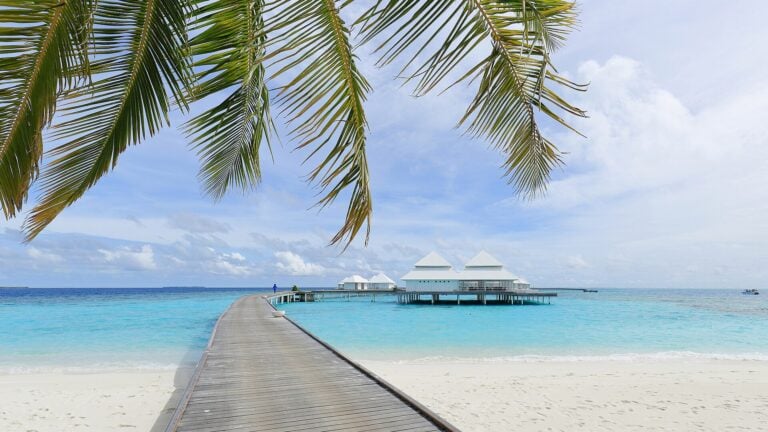 Plage des Maldives à Thudufushi — sable blanc, lagon translucide, palmiers et villa sur pilotis