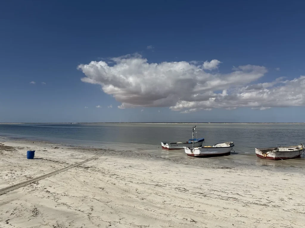 Fischerboote am Sandstrand von Hassi El Jerbi auf dem Festland gegenüber von Djerba, an flachem, ruhigem Wasser